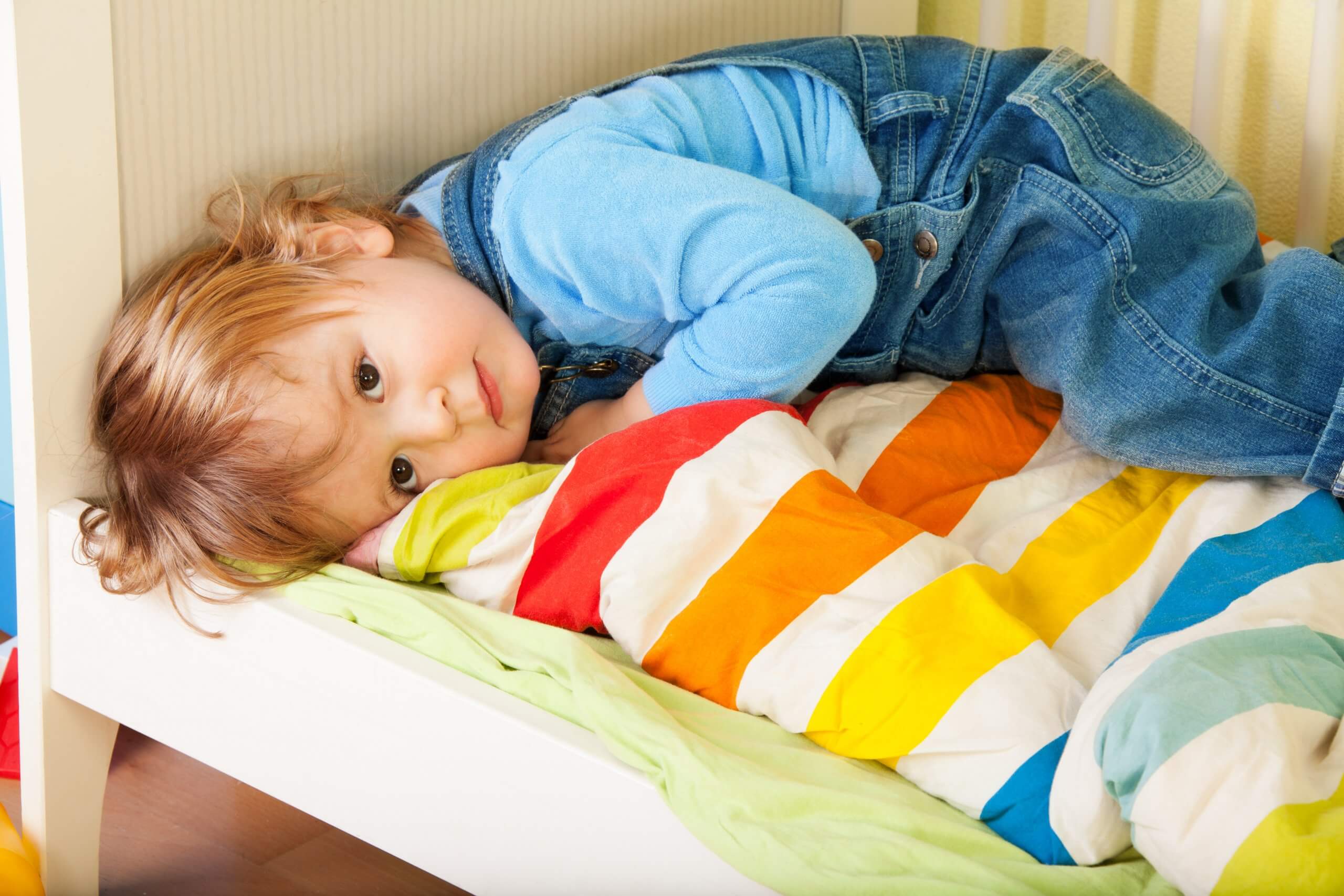 Tired Toddler Laying In His Bed